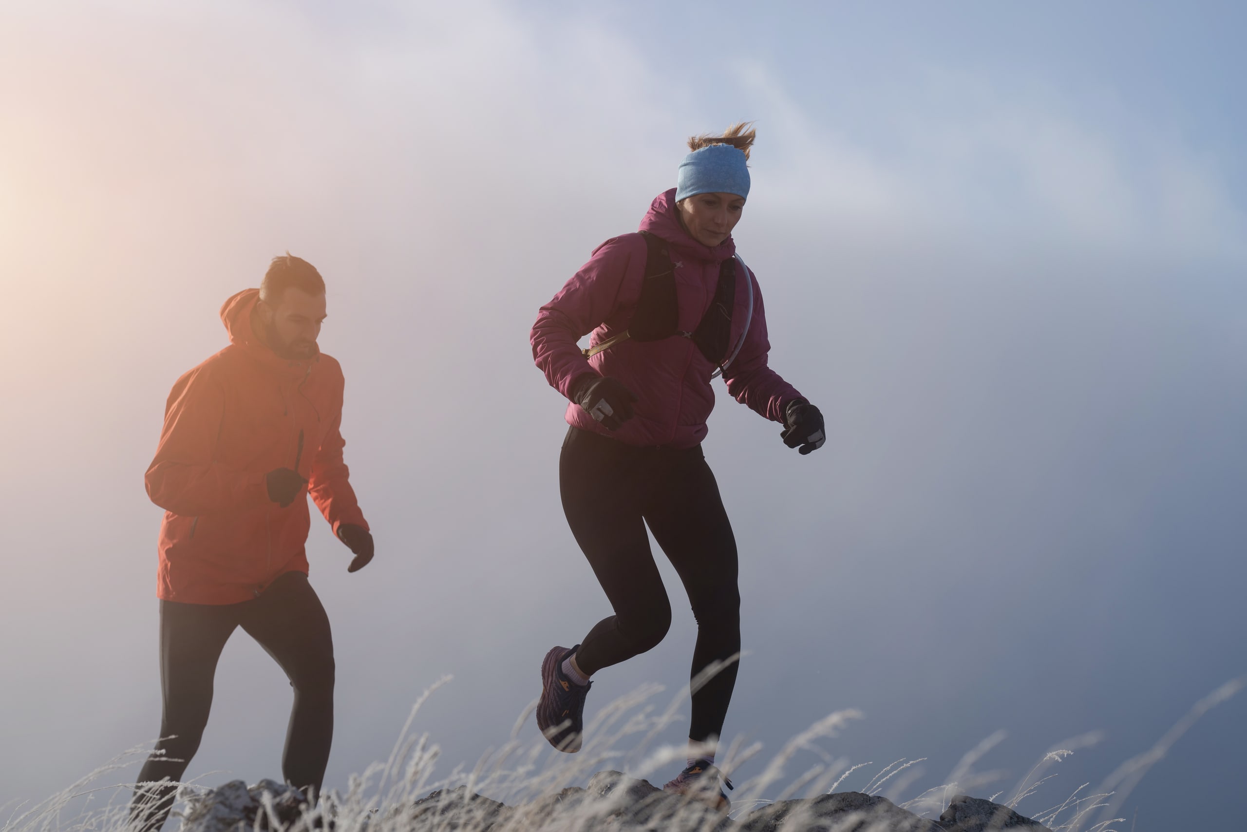 Trail runner moving through mountain mist at dawn — controlled authentic sport photography